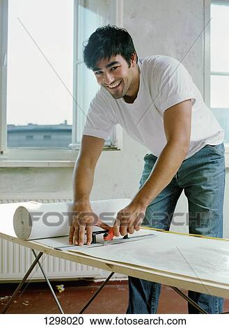 A man cutting paper with work tool, portrait View Large Photo Image Stock Image - A man cutting paper with work tool, portrait. Fotosearch