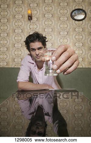 A man toasting with a shot glass View Large Photo Image Stock Photography - A man toasting with a shot glass. Fotosearch