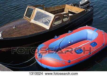 A retro motorboat moored next to a new inflatable boat View Large Photo Image Picture - A retro motorboat moored next to a new inflatable boat . Fotosearch