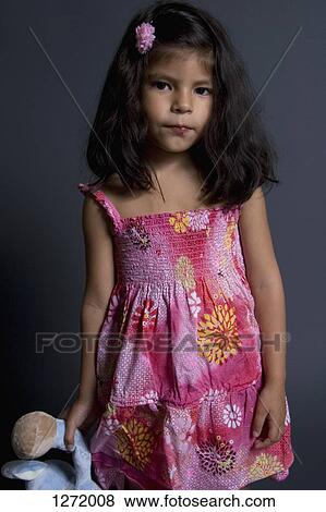 A young girl holding a stuffed toy and looking sadly into the camera View Large Photo Image Stock Photo - A young girl holding a stuffed toy and looking sadly into the camera. Fotosearch