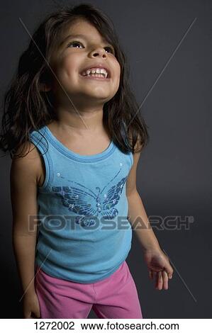 Stock Image - A young girl looking up with a big smile on her face. Fotosearch