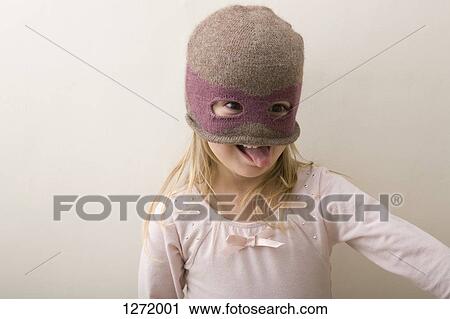 A young girl wearing a knit balaclava and sticking her tongue out mischievously View Large Photo Image Stock Image - A young girl wearing a knit balaclava and sticking her tongue out mischievously. Fotosearch