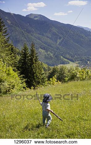 Baby boy holding stick and walking in field View Large Photo Image Stock Photo - Baby boy holding stick and walking in field. Fotosearch
