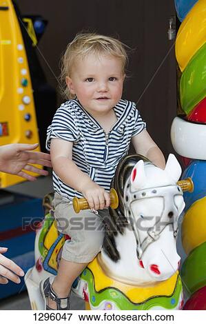 Baby boy riding an amusement ride horse View Large Photo Image Stock Photo - Baby boy riding an amusement ride horse. Fotosearch