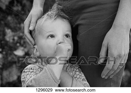 Stock Photo - Baby boy with mother, looking away. Fotosearch