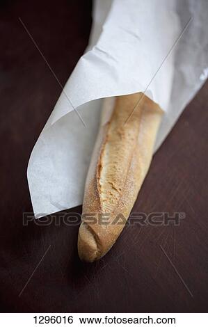 Baguette wrapped in paper, close-up View Large Photo Image Stock Photograph - Baguette wrapped in paper, close-up. Fotosearch