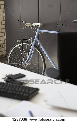 Bicycle at office table View Large Photo Image Stock Photo - Bicycle at office table. Fotosearch