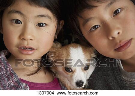 Picture - Boy and girl with dog, close-up. Fotosearch