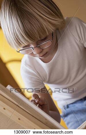 Boy drawing on easel, close-up View Large Photo Image Stock Photo - Boy drawing on easel, close-up. Fotosearch