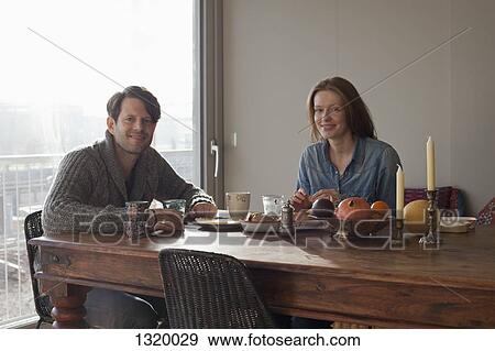 Couple having breakfast at dining table, portrait View Large Photo Image Stock Photo - Couple having breakfast at dining table, portrait. Fotosearch