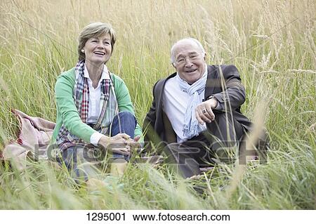 Couple sitting in field View Large Photo Image Stock Image - Couple sitting in field. Fotosearch