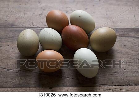 Stock Photograph - Eggs on wooden table, close-up. Fotosearch