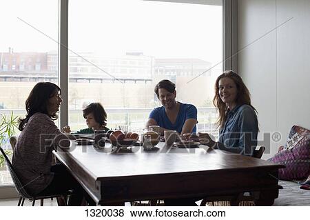 Stock Photo - Family having breakfast at dining table. Fotosearch