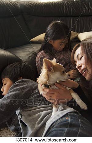 Family with dog in living room View Large Photo Image Picture - Family with dog in living room. Fotosearch