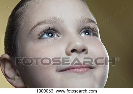 Stock Image - Girl looking up and smiling, close-up. Fotosearch