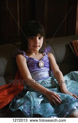 Stock Image - Girl wearing a princess costume and smiling shyly. Fotosearch