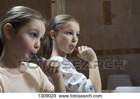 Girls brushing teeth in bathroom View Large Photo Image Stock Photo - Girls brushing teeth in bathroom. Fotosearch