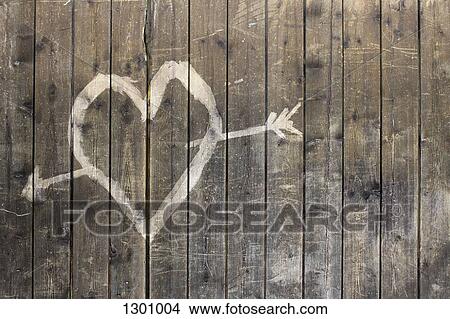 Heart shape with arrow symbol on wooden fence View Large Photo Image Picture - Heart shape with arrow symbol on wooden fence. Fotosearch