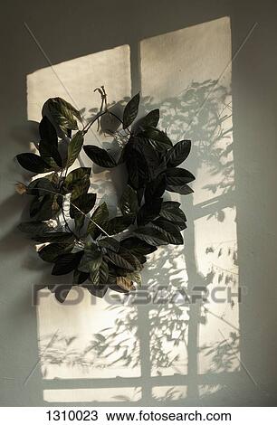 Stock Image - Leaf wreath on wall. Fotosearch