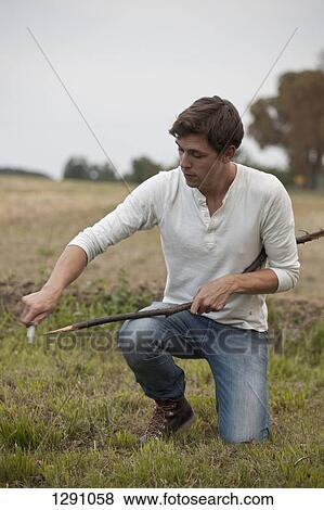Man cutting stick with knife View Large Photo Image Stock Photo - Man cutting stick with knife. Fotosearch