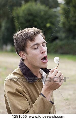 Stock Photography - Man holding dandelion flower. Fotosearch