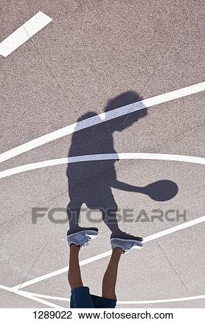 Stock Image - Man playing basketball, low section. Fotosearch