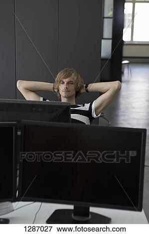 Stock Photo - Man relaxing at computer desk. Fotosearch