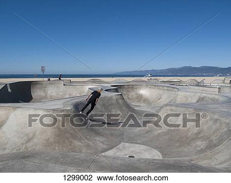 Stock Image - Man skateboarding in skateboard park, Venice Beach, California. Fotosearch