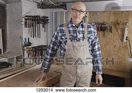 Picture - Mature man standing in carpenter shop, portrait. Fotosearch