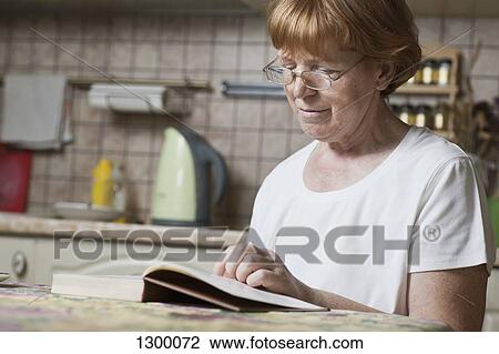 Stock Image - Mature woman reading book. Fotosearch