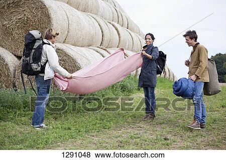 Men and woman with camping accessories standing in field View Large Photo Image Stock Photo - Men and woman with camping accessories standing in field. Fotosearch