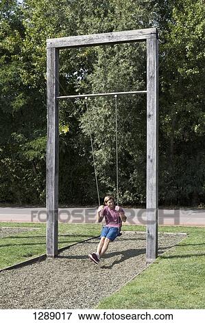 Mid adult man swinging in park View Large Photo Image Stock Photo - Mid adult man swinging in park. Fotosearch