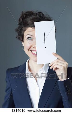 Mid adult woman holding paper with exclamation mark and smiling, close-up View Large Photo Image Stock Image - Mid adult woman holding paper with exclamation mark and smiling, close-up. Fotosearch