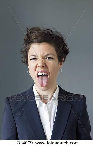 Stock Photo - Mid adult woman sticking tongue out in disgust, close-up. Fotosearch
