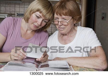 Mother and daughter looking at photographs View Large Photo Image Stock Photography - Mother and daughter looking at photographs. Fotosearch