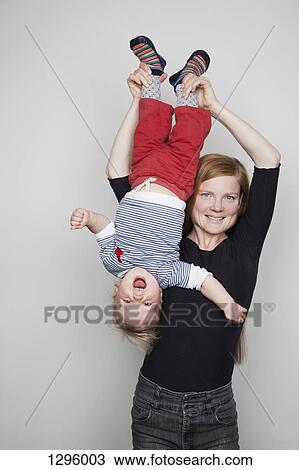 Mother holding baby boy upside down View Large Photo Image Stock Image - Mother holding baby boy upside down. Fotosearch