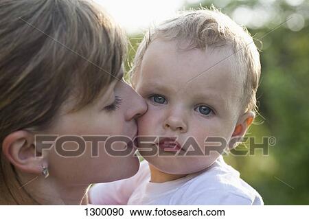 Stock Image - Mother kissing her son, close-up. Fotosearch