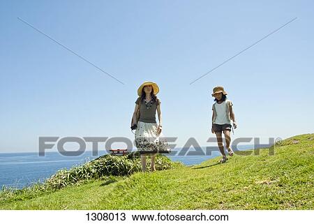 Mother walking with daughter at coastline View Large Photo Image Stock Image - Mother walking with daughter at coastline. Fotosearch