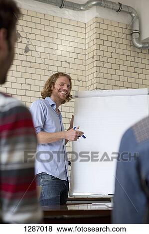 Stock Photo - Office colleagues in boardroom meeting. Fotosearch