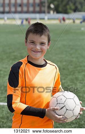 Portrait of boy holding football, smiling View Large Photo Image Stock Image - Portrait of boy holding football, smiling. Fotosearch