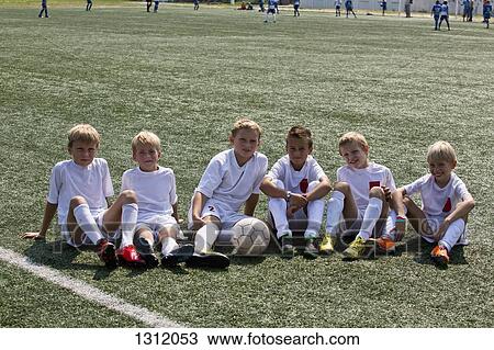 Portrait of boys sitting on football pitch View Large Photo Image Stock Image - Portrait of boys sitting on football pitch. Fotosearch