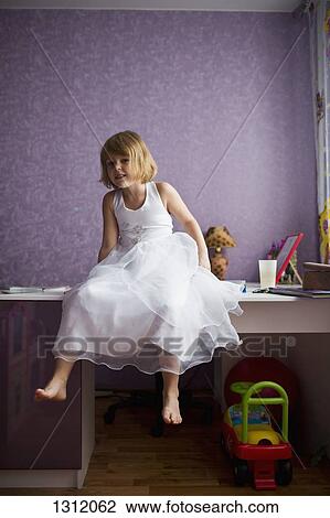 Stock Image - Portrait of girl sitting on table. Fotosearch