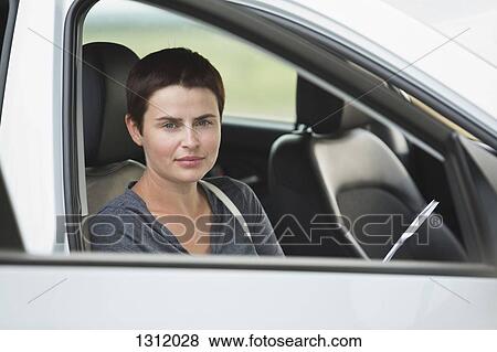 Portrait of mid adult woman sitting in car View Large Photo Image Stock Photo - Portrait of mid adult woman sitting in car. Fotosearch