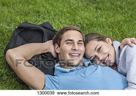 Portrait of young couple lying on grass View Large Photo Image Stock Photo - Portrait of young couple lying on grass. Fotosearch