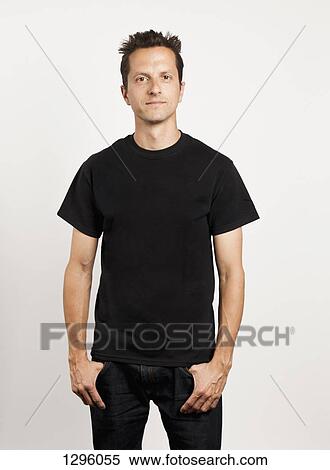 Portrait of young man standing against white background View Large Photo Image Stock Photography - Portrait of young man standing against white background. Fotosearch