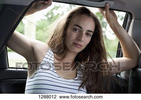 Portrait of young woman in car, close-up View Large Photo Image Stock Image - Portrait of young woman in car, close-up. Fotosearch