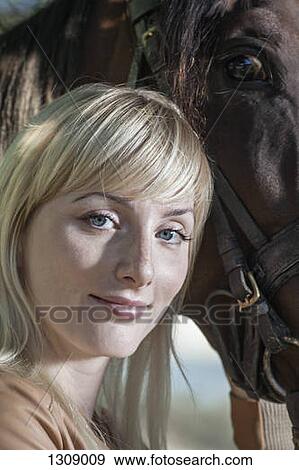 Portrait of young woman with horse, smiling View Large Photo Image Stock Photo - Portrait of young woman with horse, smiling. Fotosearch