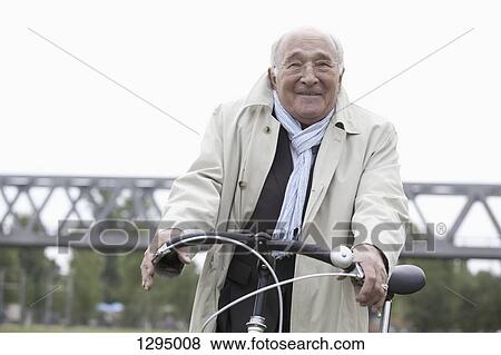 Senior man cycling bicycle View Large Photo Image Stock Photo - Senior man cycling bicycle. Fotosearch