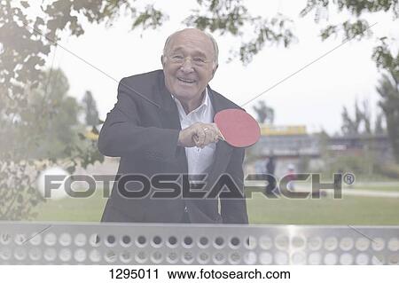 Stock Image - Senior man playing table tennis. Fotosearch