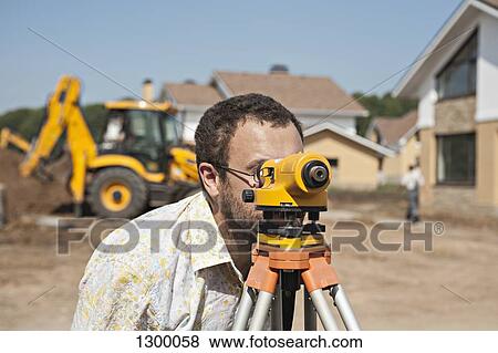 Surveyor using theodolite instrument for measuring levels on construction site View Large Photo Image Stock Photo - Surveyor using theodolite instrument for measuring levels on construction site. Fotosearch